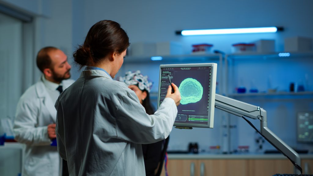 researcher looking monitor analysing brain scan while coworker discussing with patient background about side effects mind functions nervous system tomography scan working laboratory 1