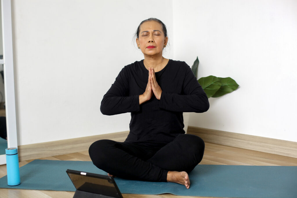 senior adult woman practicing yoga doing breathing practice home mindfulness meditation 1